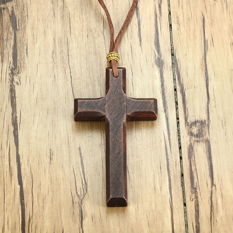 Wooden cross on brown faux suede cord.