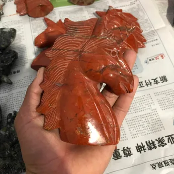 

A natural ruby sculpture of a horseshoe unicorn with a quartz crystal skull