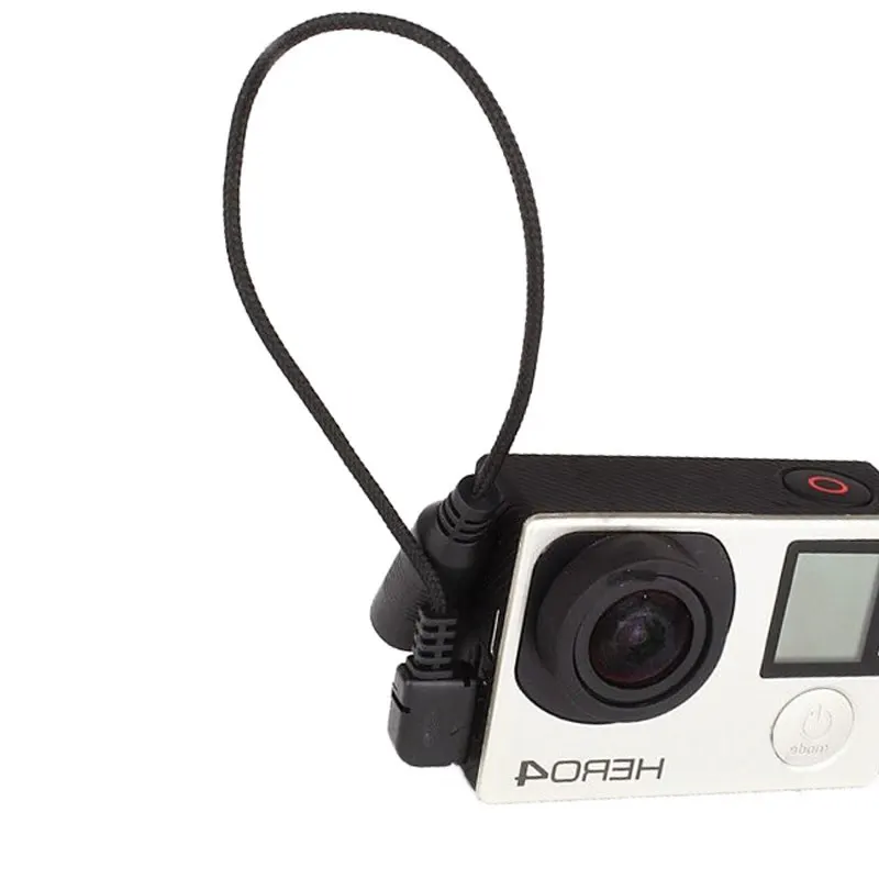 Câble adaptateur micro 3,5mm Mini USB pour GoPro Hero 3+4, posé à côté d'une GoPro Hero 4, prêt à être branché.