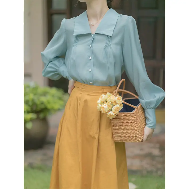 

Lake blue lantern sleeve shirt long sleeve retro court wind pearl buckle French top and yellow skirt set.