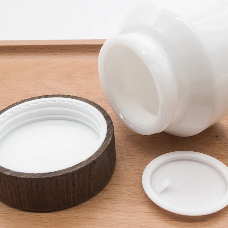 

Cosmetic porcelain white glass jars with bamboo lid 15g 50g skin care recycled luxury opal face cream glass jars dark wooden lid