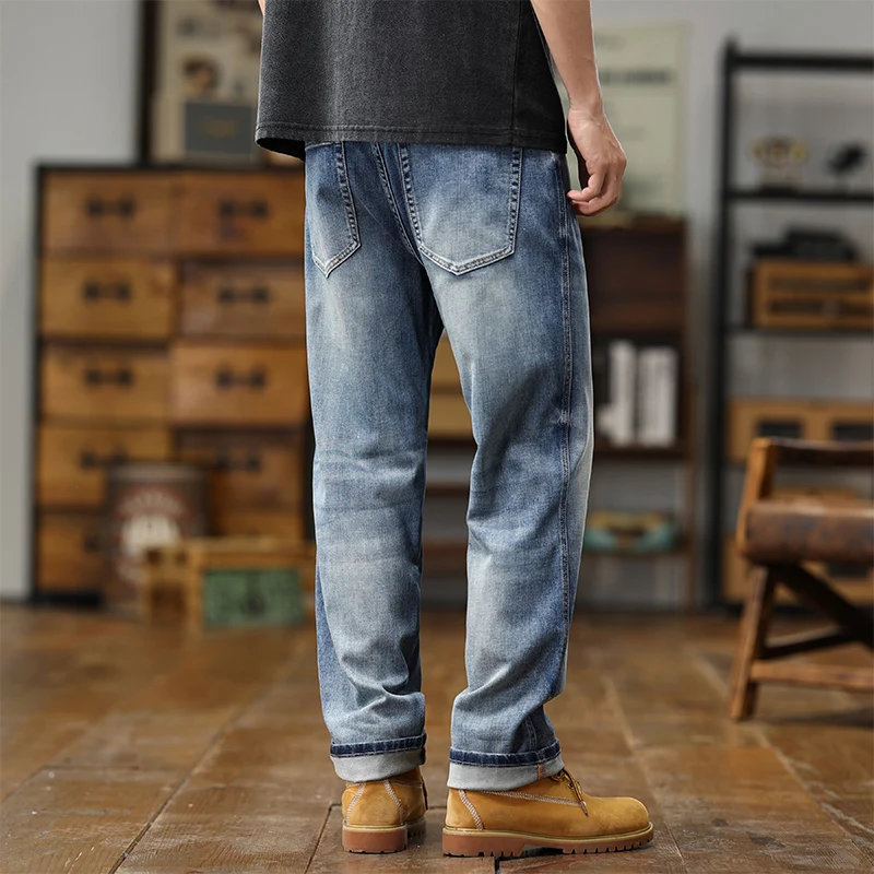 Jeans amples en denim bleu clair présentant une coupe décontractée à jambe large, avec des bas de manche retroussés, dans un denim au délavage clair.