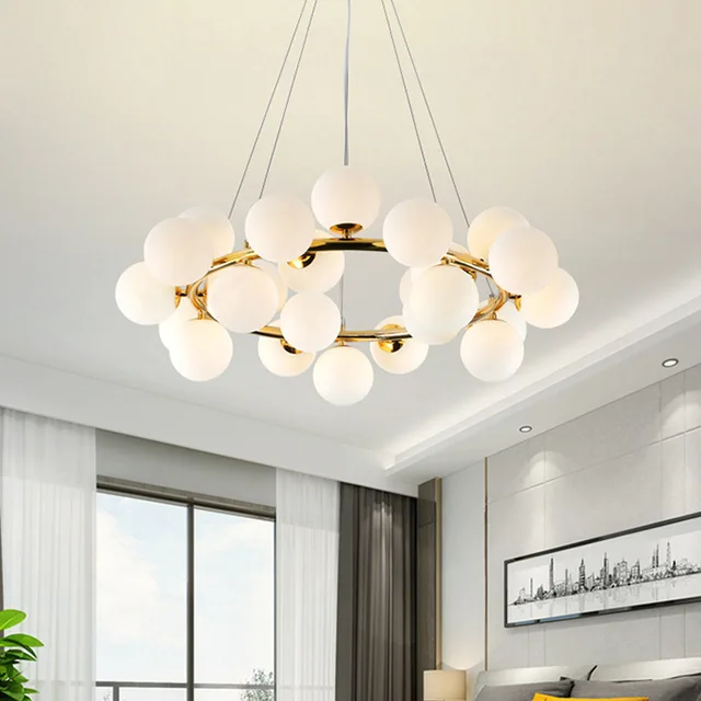 Suspension grappe LED bulles blanches et structure dorée présenté suspendu dans une chambre