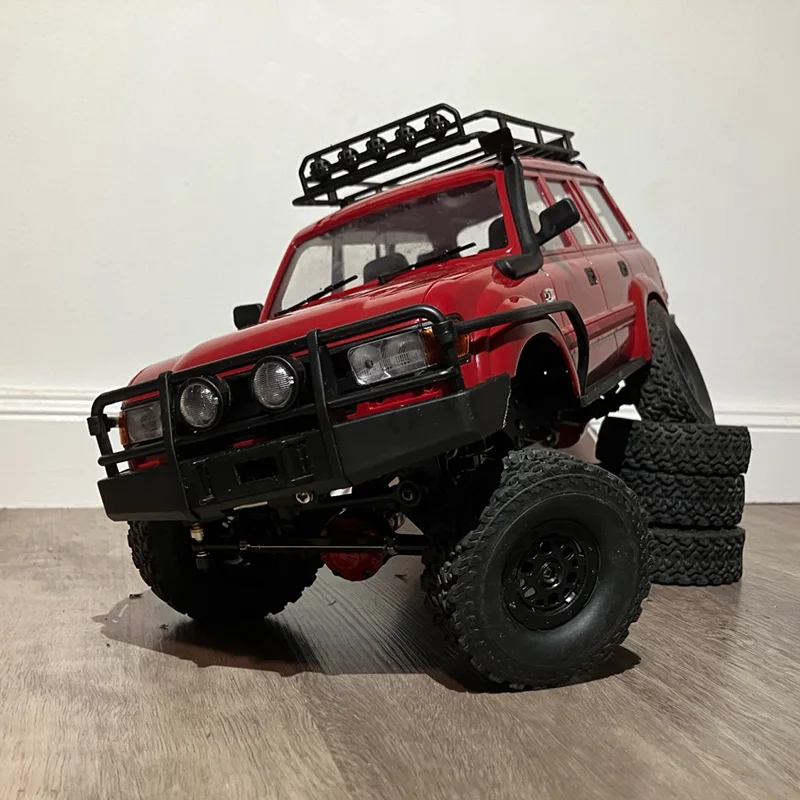 Voiture radiocommandée 4WD 1/16 C24-1 roulant dans la boue, démontrant sa capacité tout-terrain.
