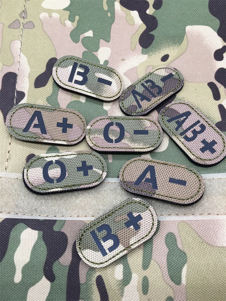 Multicam tactical hook & loop blood type patches with infrared reflective letters on camouflage fabric background
