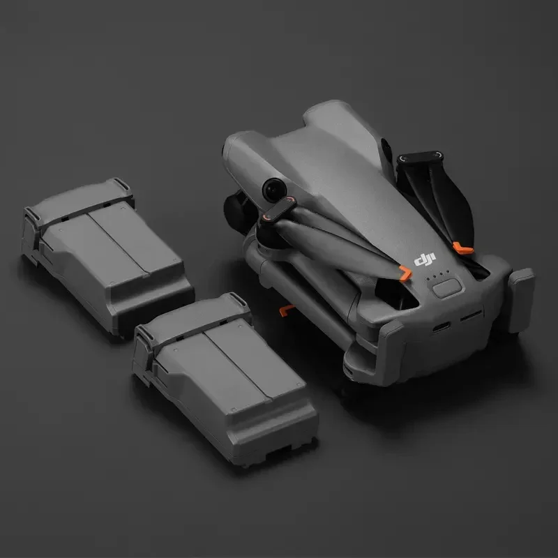 Drone posé sur une surface avec deux batteries de rechange, kit batterie pour vols prolongés.