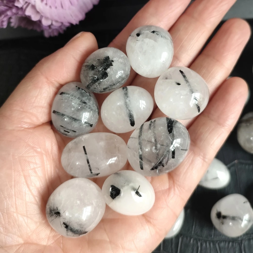 A smooth, deep black tumbled stone of Black Tourmaline, showing a shiny, rounded surface.