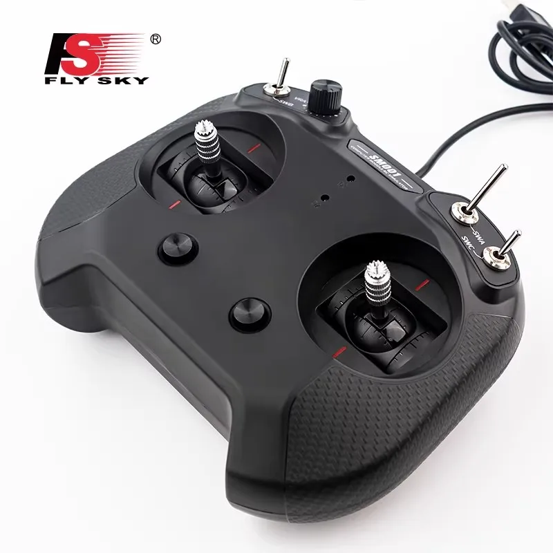 Vue rapprochée du simulateur Flysky FS-SM001 montrant les sticks et les interrupteurs pour l'entraînement