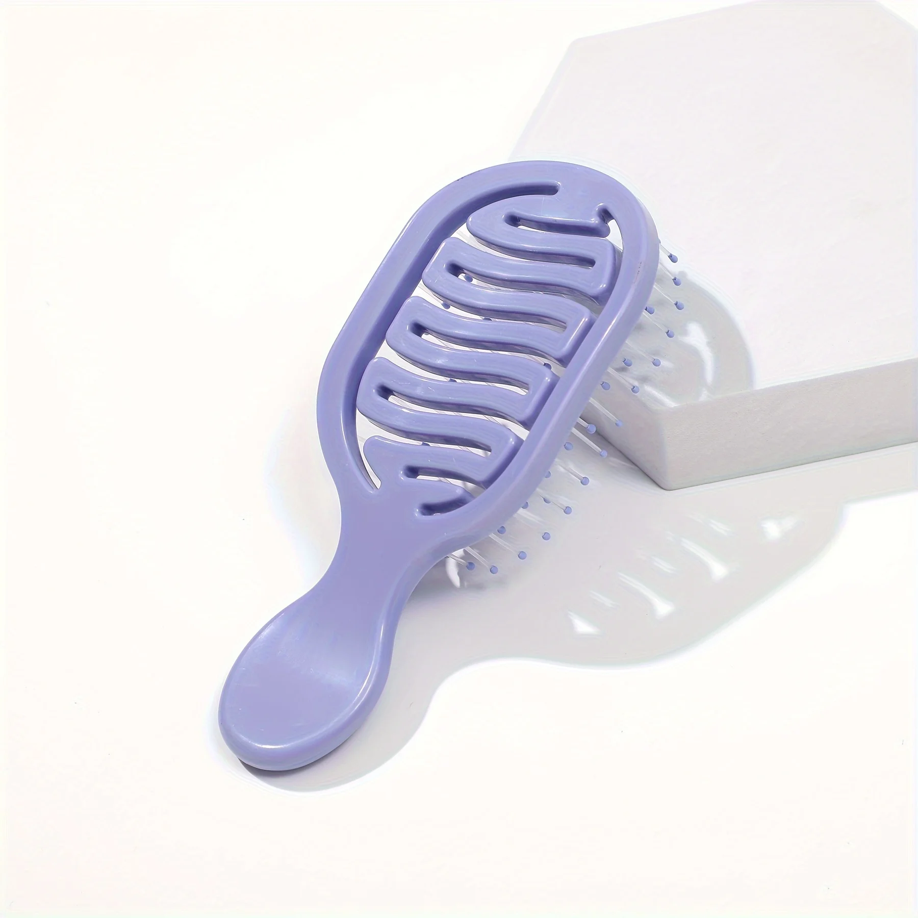 Mini Track Hairbrush, portable hollow design with nylon bristles, ergonomic handle, compact and lightweight—a travel essential.