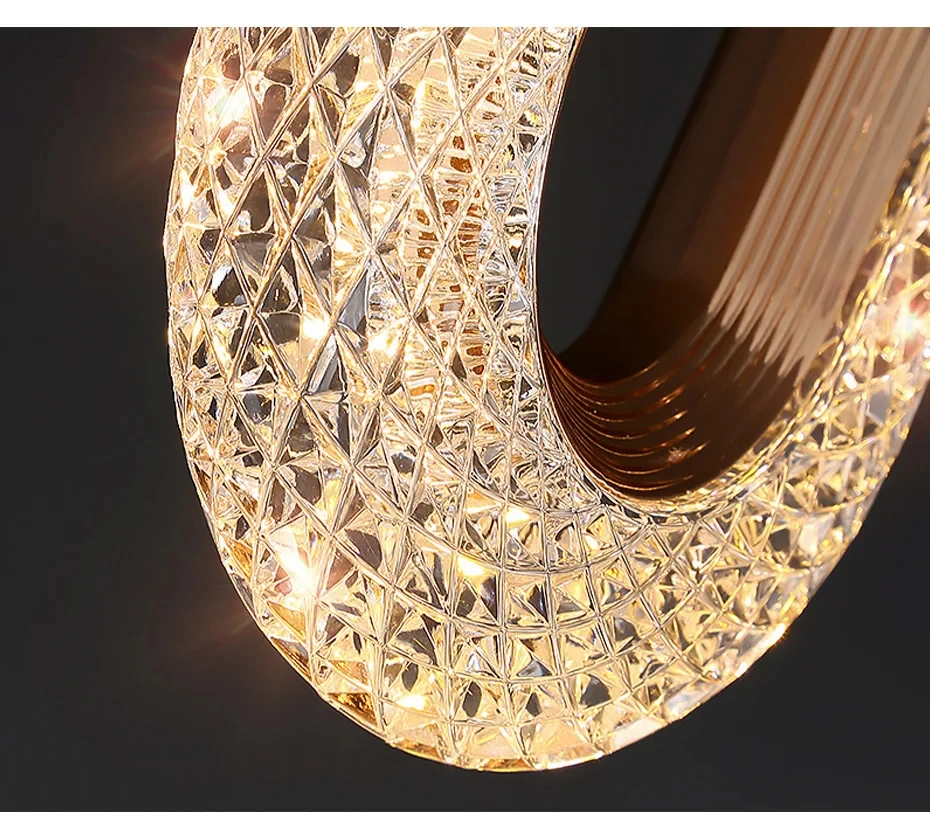 A close-up of a glowing, curved Luxury Wall Sconce with intricate, diamond-like patterns against a dark background, adding a modern and stylish touch to indoor lighting.