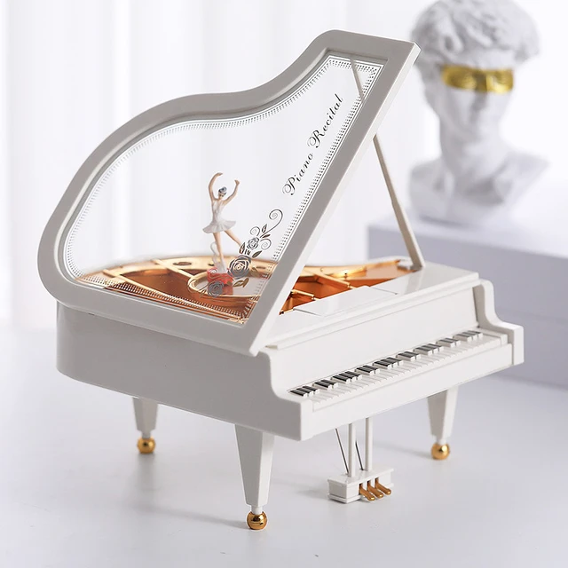 Preciosa caja de música con forma de piano.Incluye banco y caja rígida