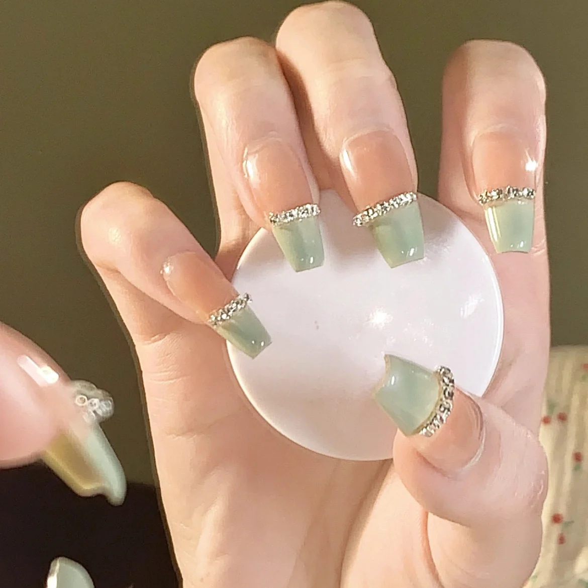 

Artificial nails worn by hand show white cinnamon milk green diamond chain nail enhancement, detachable and long-lasting