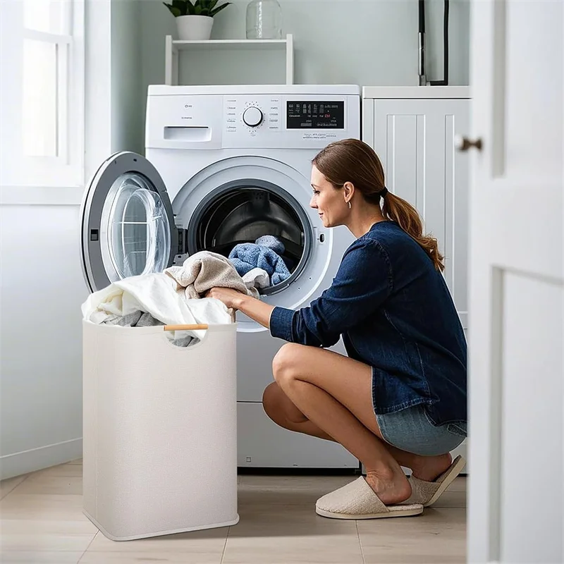 Vrouw laadt wasgoed in ivoorkleurige wasmand naast wasmachine