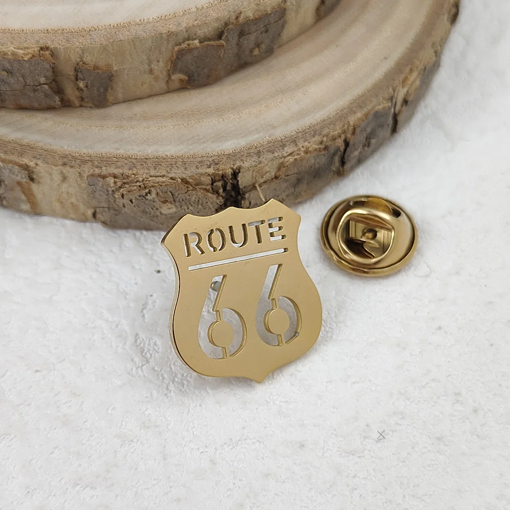 Route 66 shield lapel pin in Gold 316L stainless steel, close-up showing engraved detail and butterfly clutch
