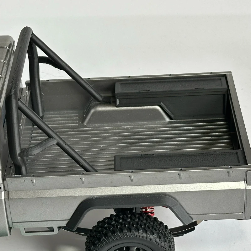 Vue latérale du RC Rock Crawler 1/12 avec sa cage de protection, accessoire décoratif renforçant le look off-road.