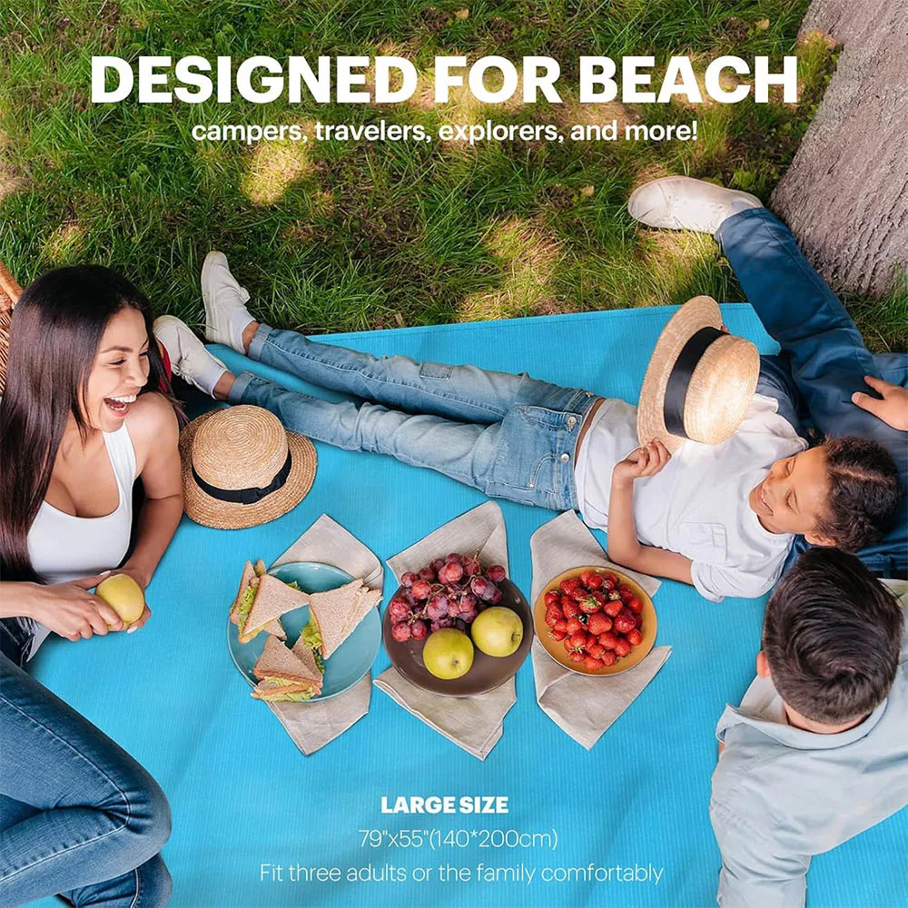 Large blue beach blanket spread out on sand