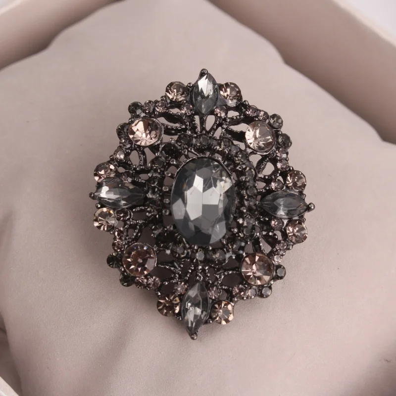 Elegant Vintage-Style Brooch with Dark Crystals and Ornate Hollow Design