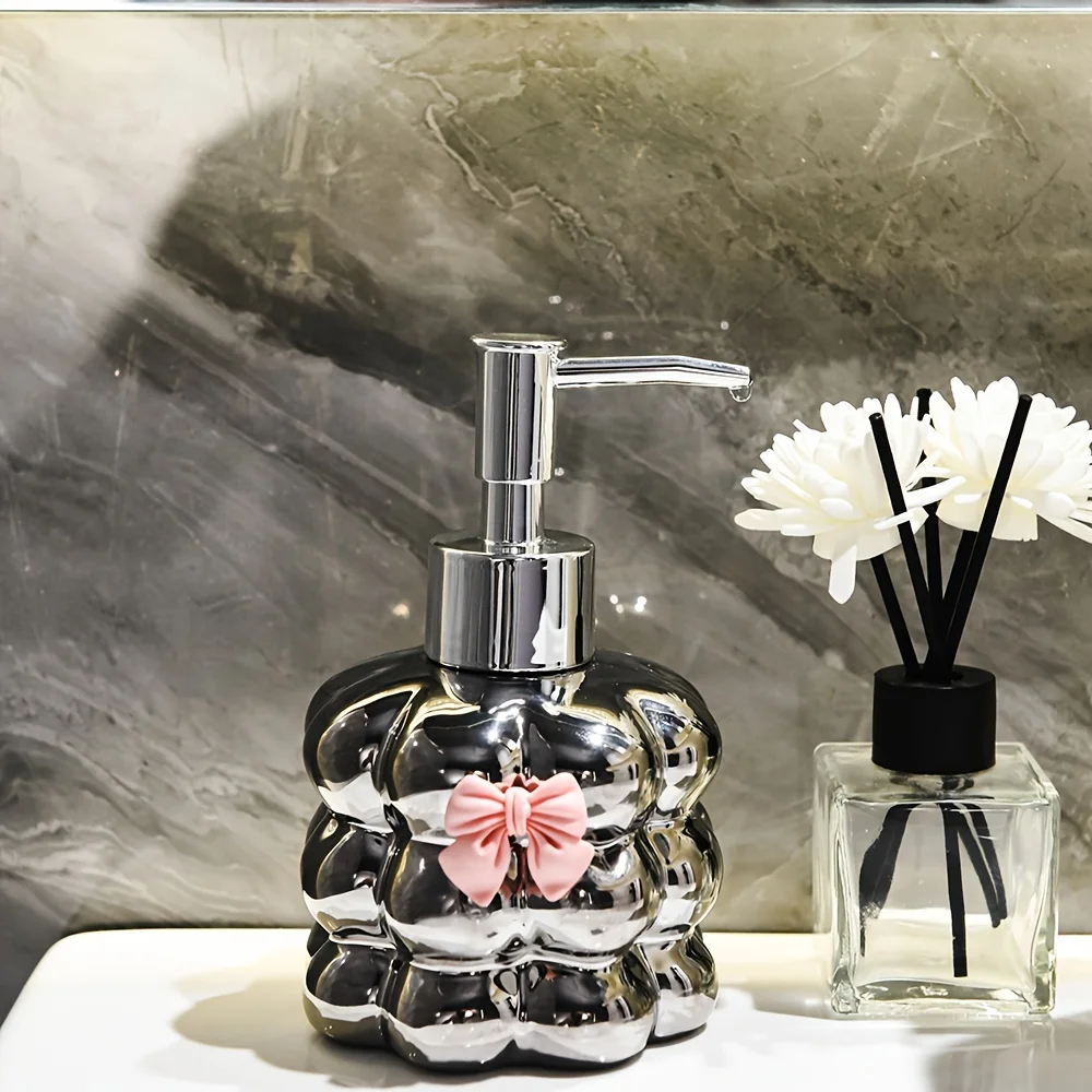موزع صابون بتصميم زهرة سيراميك، وموزع لوشن كونترتوب، وزجاجة معقم لليدين في الحمام