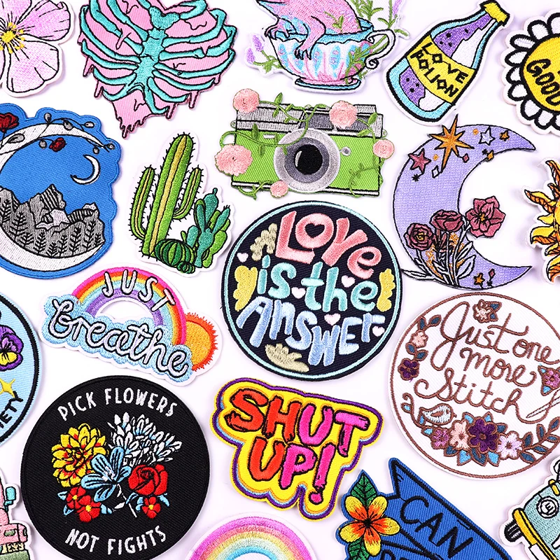 Collection of colorful patches with various designs and text on a white background