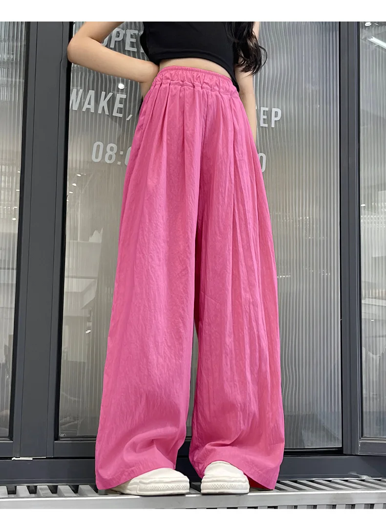 Teen girls’ casual summer wide-leg pants in lightweight fabric, styled with sandals and a simple tee on a beach boardwalk backdrop red