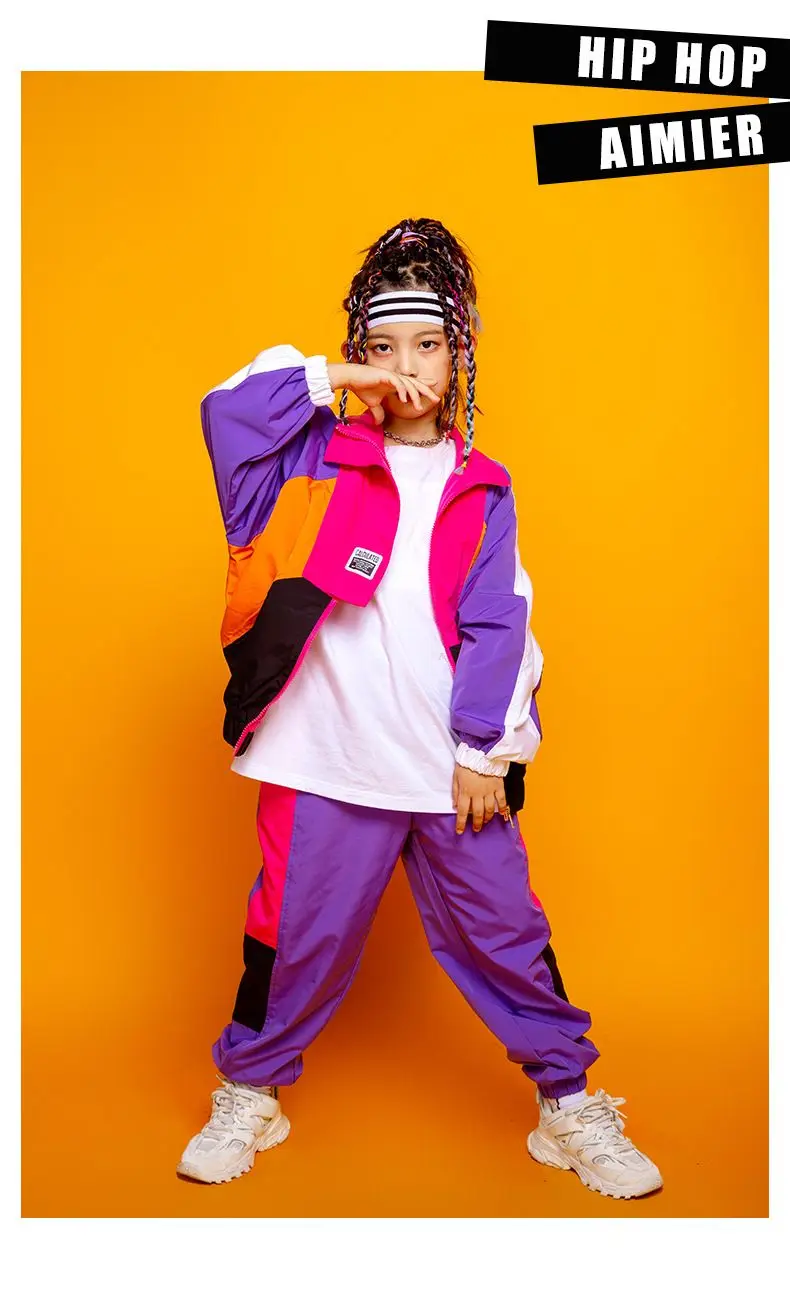 Child wearing patchwork jacket and joggers in hip hop street dance pose 6547