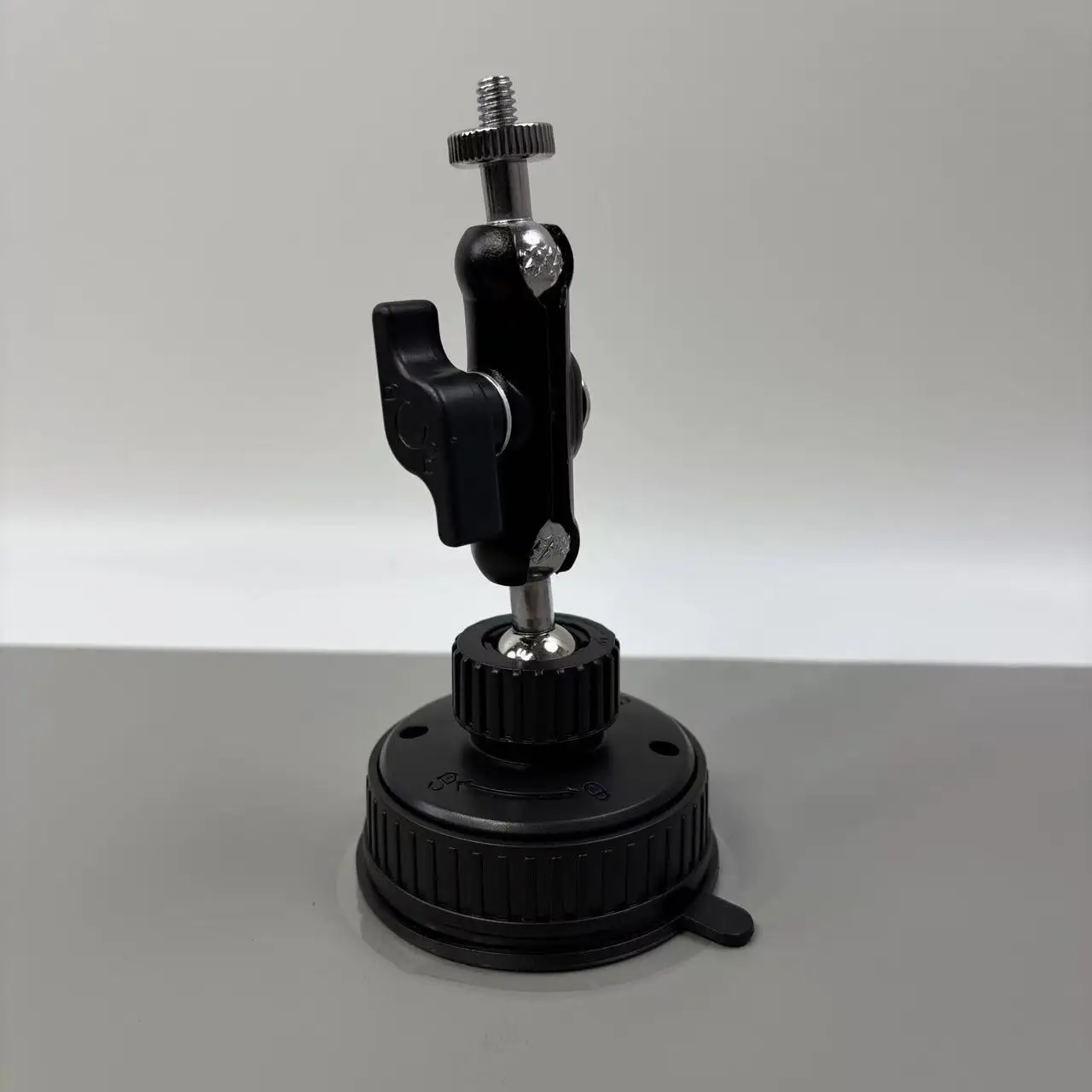 Fixation solide pour dashcam avec ventouse et bras articulé, maintenant une action cam en position paysage.