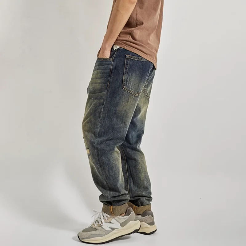 穴が開いた男性用ストレートレッグジーンズとディストレスト