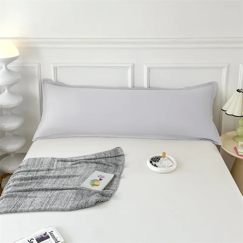 Long pillow cover arranged across a bed