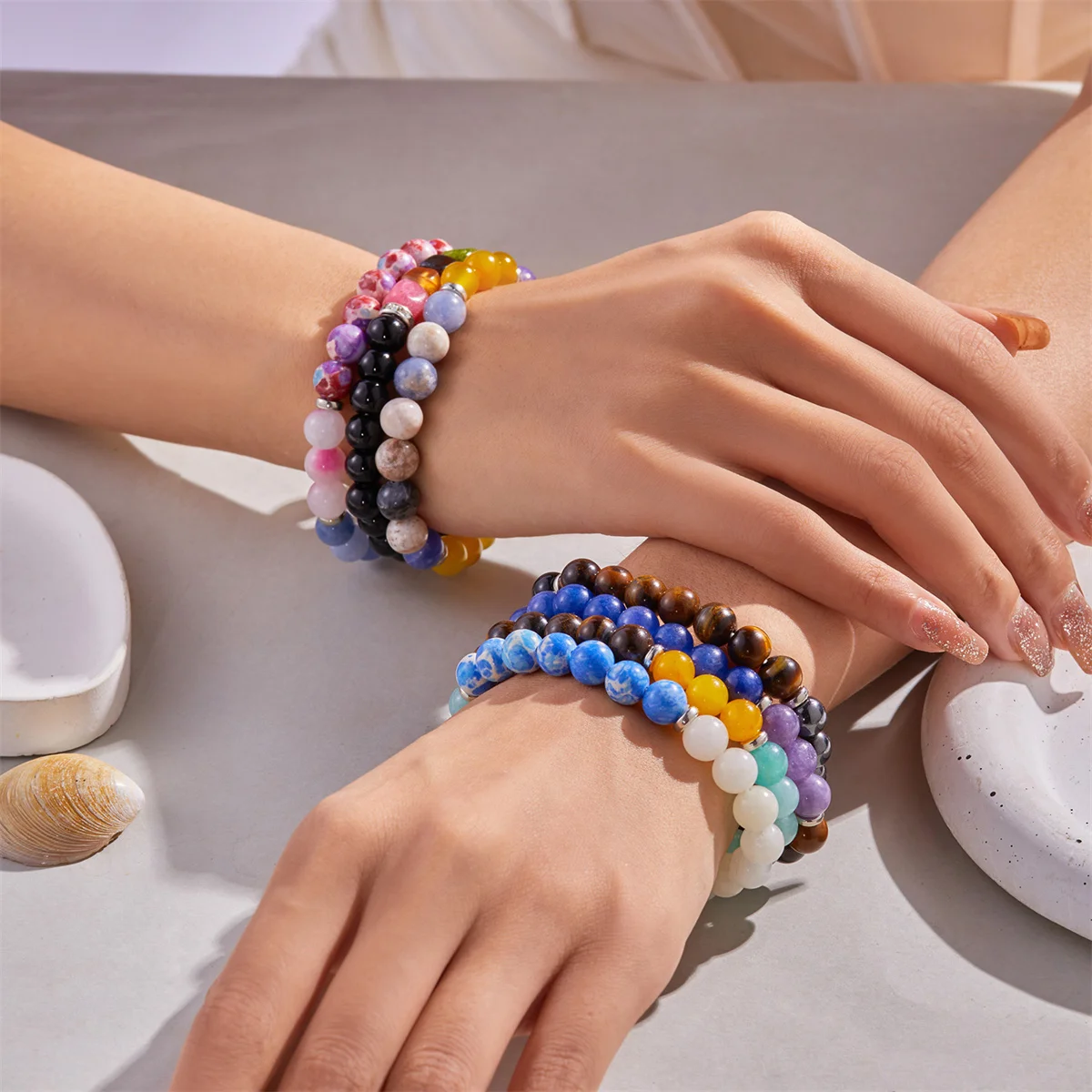 Elegant beaded bracelets arranged beside candles