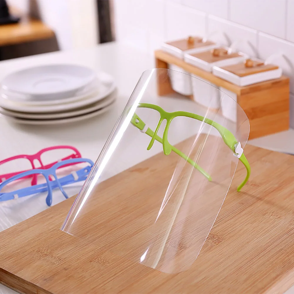 Détail du système d'attache d'un écran de protection faciale anti-éclaboussures pour lunettes, avec élastique et clips.