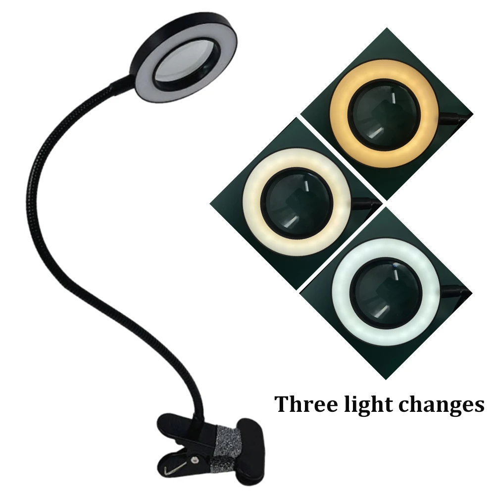 Lampe loupe LED avec clip pour modélisme, fixée sur un établi, éclairant une pièce de modélisme en lumière blanche.