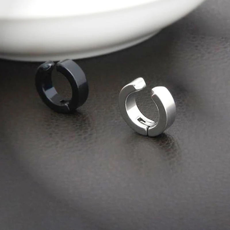 Lifestyle shot of a person wearing black stainless steel clip-on hoop earrings