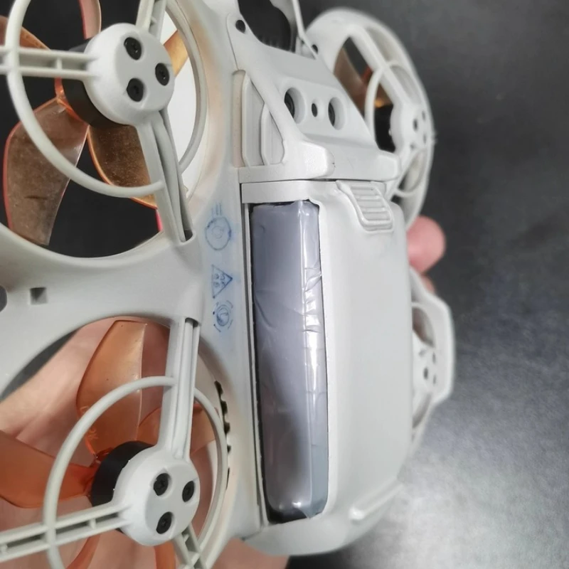 Batterie DJI NEO 3300mAh branchée sur un chargeur, LED allumée indiquant la charge.