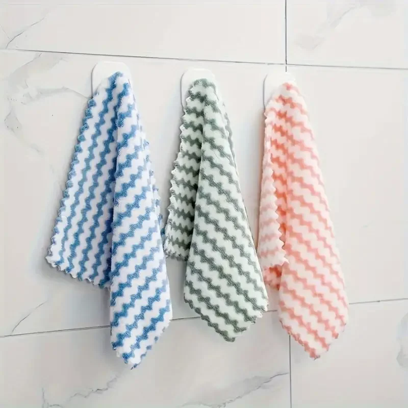 Stack of coral velvet wave-pattern kitchen wipes in assorted colors, placed beside a spray bottle and sponge on a clean countertop 3 colors