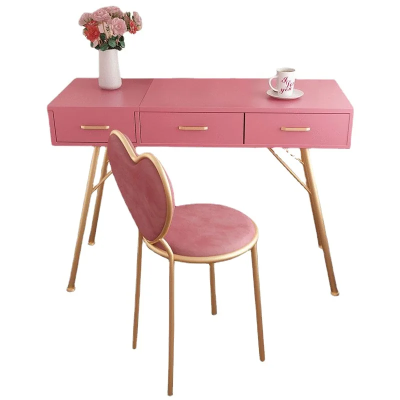 Commode rose de style princesse dans une chambre d’étudiante, table de maquillage simple avec tiroirs, placée contre le mur. 1