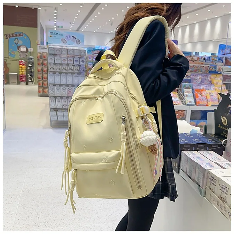 Sac à dos TRAVEASY 2026 Nouveau Motif Nœud Mignon Polyvalent en Nylon avec Pendentif Pompon Protection Dorsale pour Étudiants