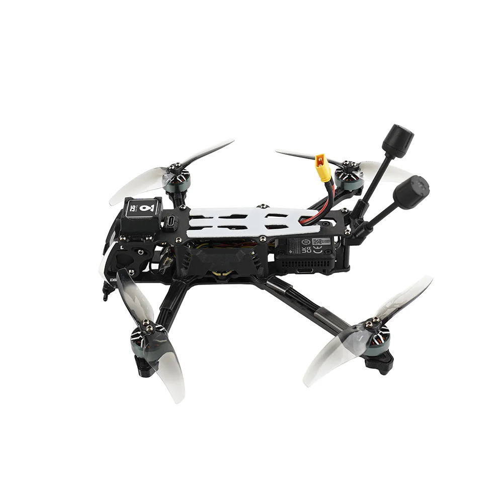 Drone FPV Analog ou DJI O4 Pro avec GPS en action dans le ciel, volant au-dessus d'un champ.