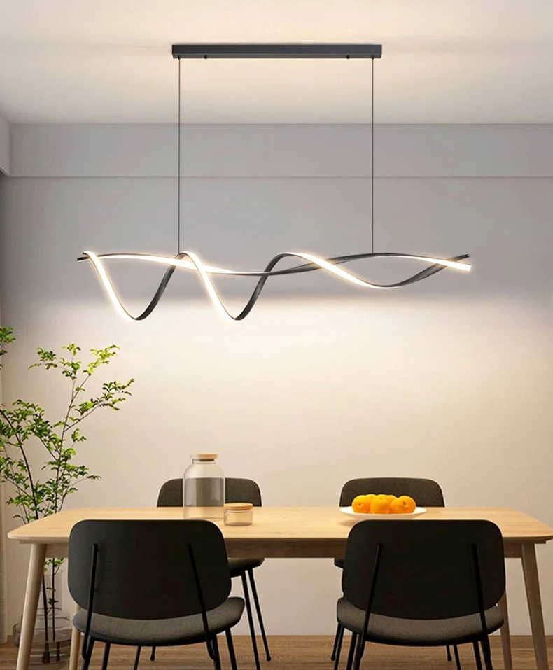 A modern dining area includes a wooden table, black chairs, and the Stylish Pendant Light featuring LEDs. A plant enhances the corner while a bowl of oranges on the table highlights minimalist design.