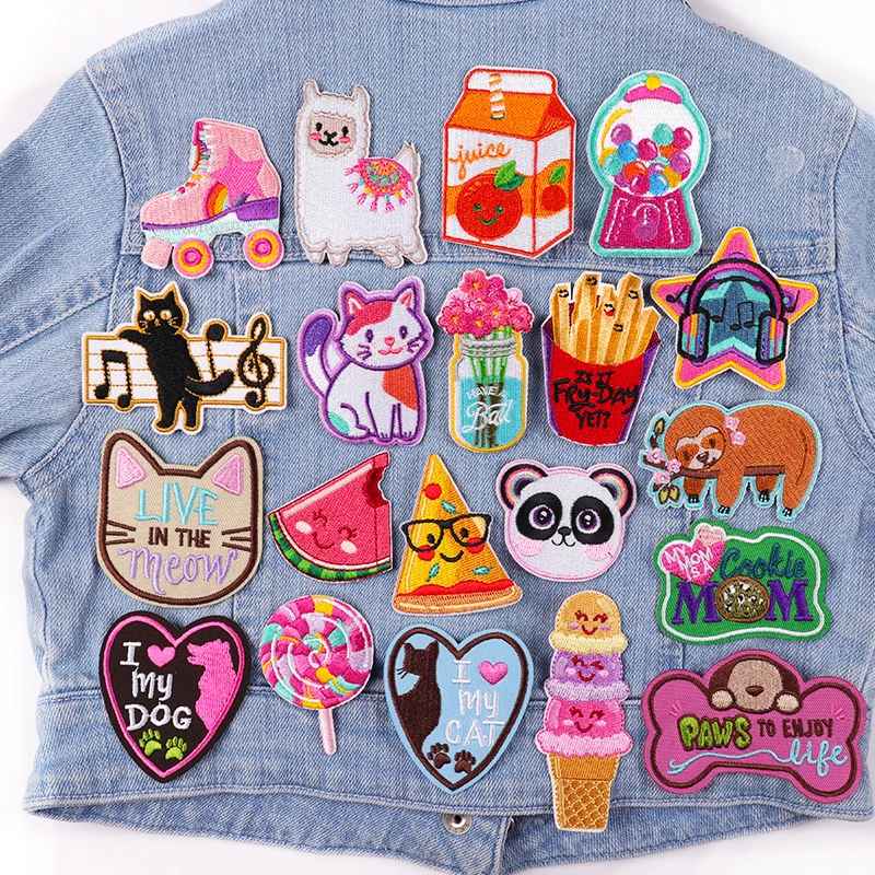 Denim jacket with various colorful patches including animals, food, and phrases.