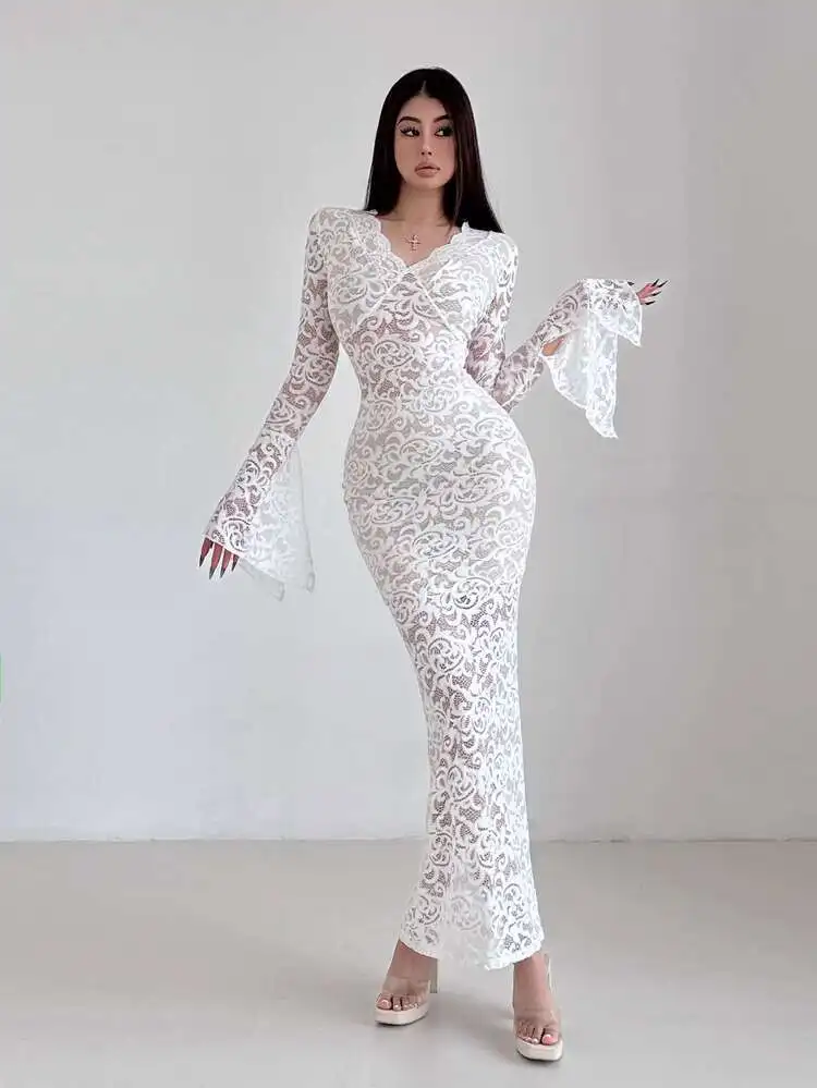 Woman wearing an elegant white sheer lace maxi dress with deep v neck and flared long sleeves.