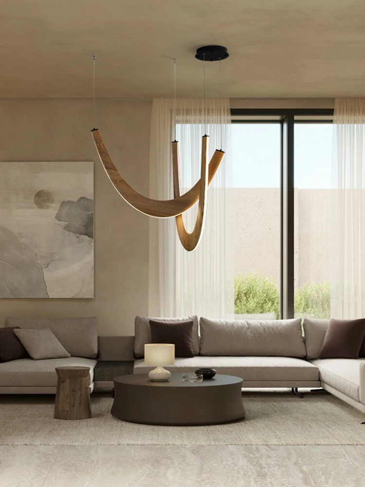 Modern living room with neutral tones, large windows, two sofas, round coffee table, abstract wall art, and the Double Curve Wood Pendant Light elegantly hanging from the ceiling.