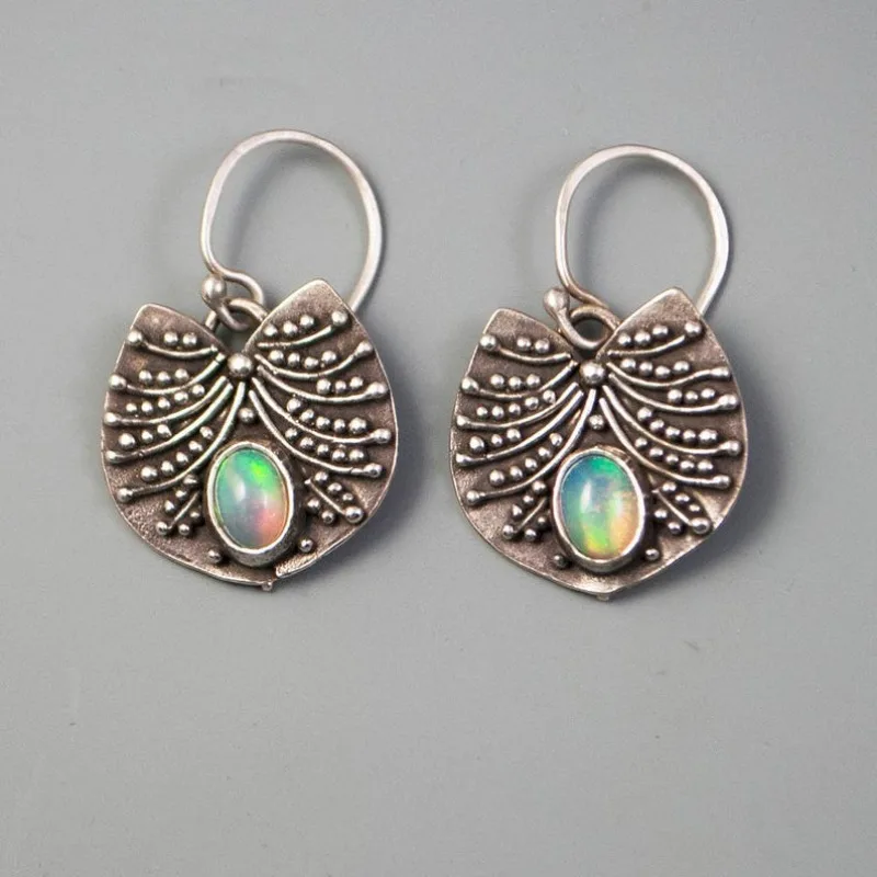 Ethnische silberfarbene Metallschnitzmuster ovale eingelegte Imitation Mondstein baumelnde Ohrringe für Frauen Schmuck
