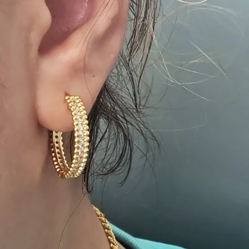 A woman's ear with trendy Rhinestone Round Stud Earrings for Women.