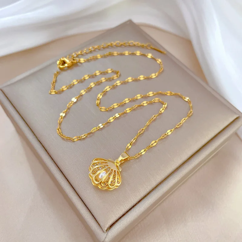 un collier doré avec pendentif sur une boite de bijoux 