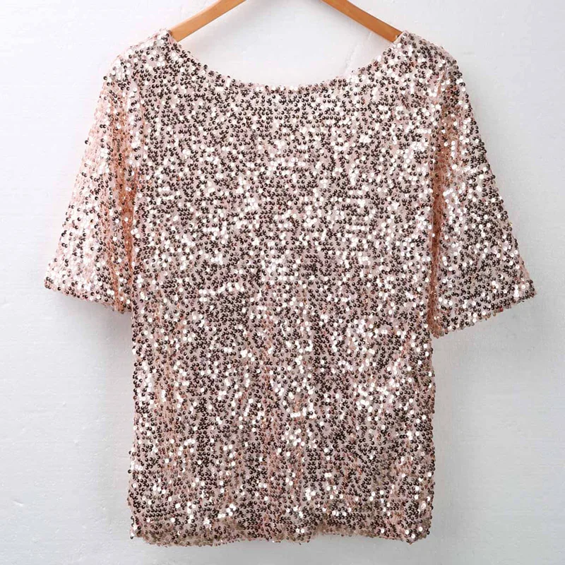 Woman wearing sloping shoulder sequin T-shirt in a casual streetwear setting with soft lighting 05
