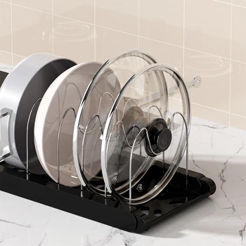 An adjustable black cabinet pot rack organizing several frying pans and lids vertically inside a white kitchen cabinet.