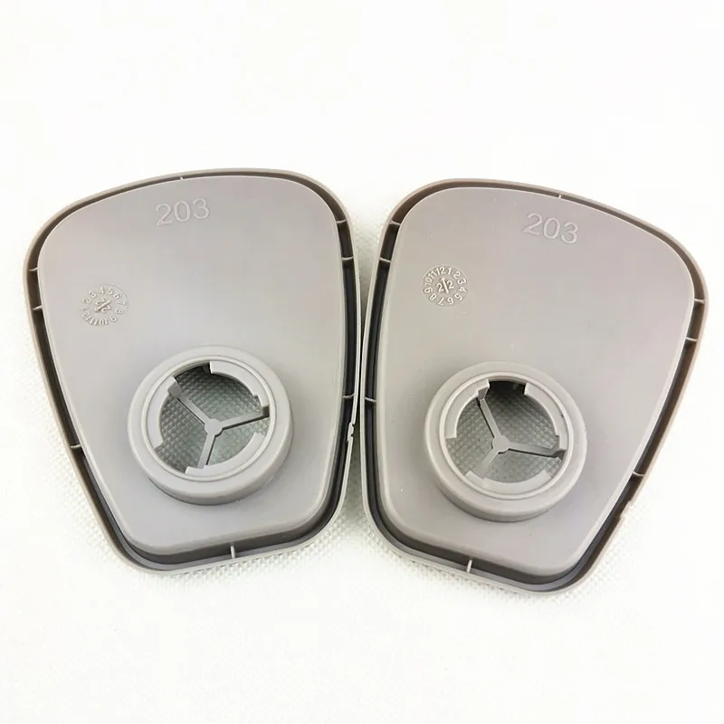 Adaptateur de filtre SJL 603 posé à côté d'un masque 3M série 6000, vue d'ensemble