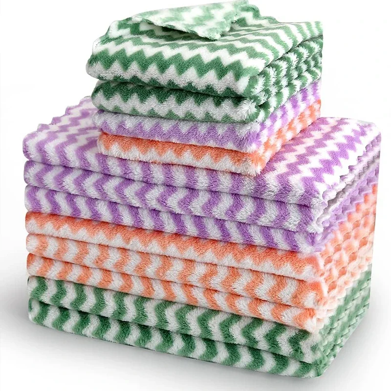 Stack of coral velvet wave-pattern kitchen wipes in assorted colors, placed beside a spray bottle and sponge on a clean countertop multicolor
