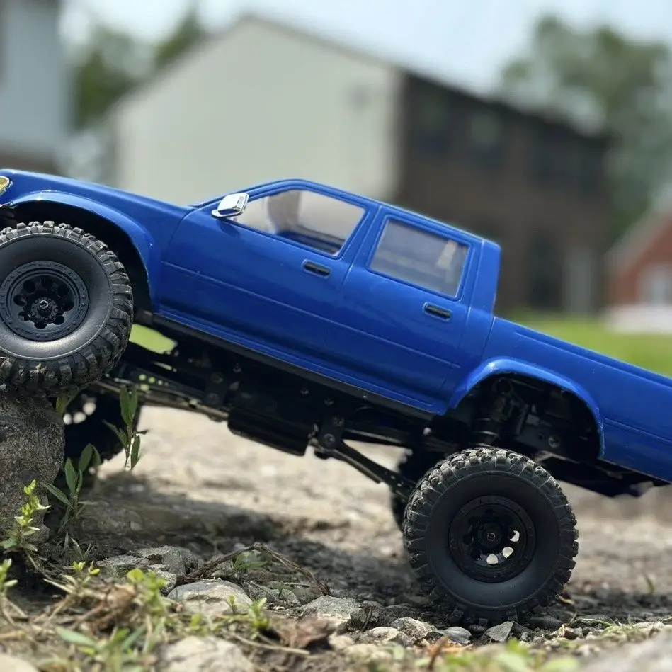 Voiture télécommandée tout-terrain 1/16 4CH 2.4G - C64-1 Bleu, vue arrière montrant le châssis et les roues.