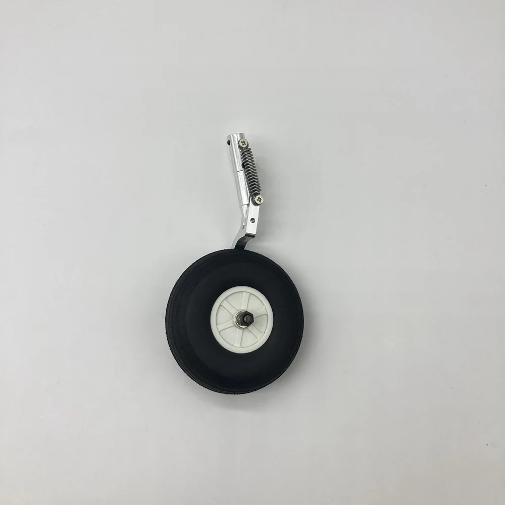 Le train d'atterrissage principal RC Warbird DIY 140mm pour PC21 1100mm avec une roue et un axe métallique, prêt à être installé.